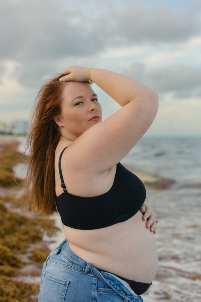 Natural maternity beach portrait in jeans during golden hour in Miami.