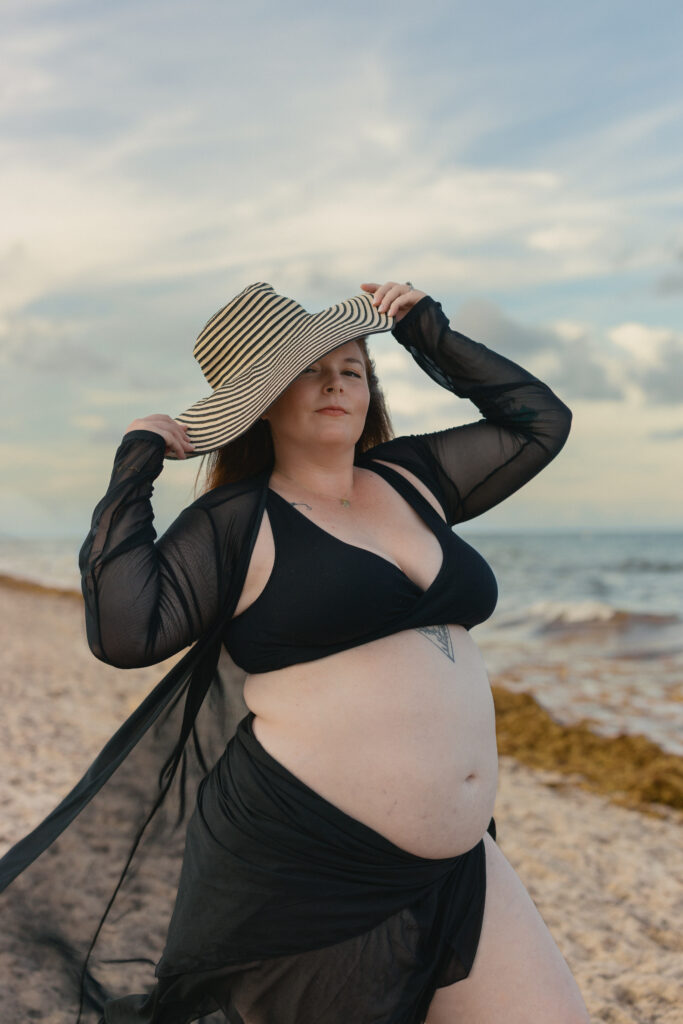 Fashion-inspired maternity beach portrait with wide brim hat in Miami.