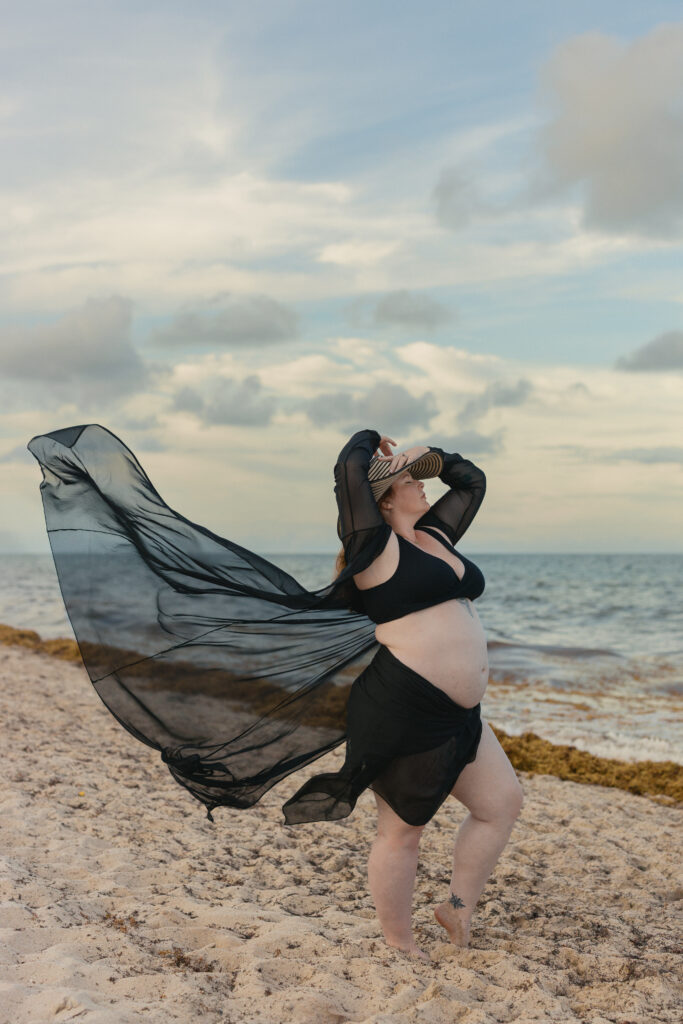 Editorial maternity beach session with flowing black fabric at sunset in Miami.