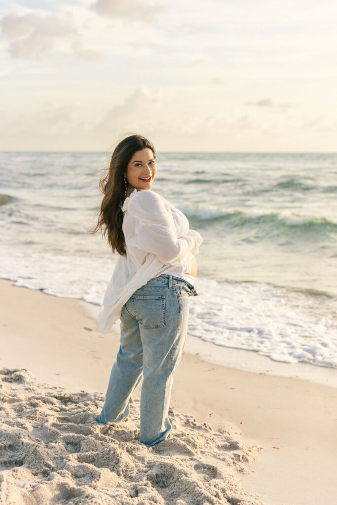 Expecting mother smiling during a Miami beach maternity session at golden hour.