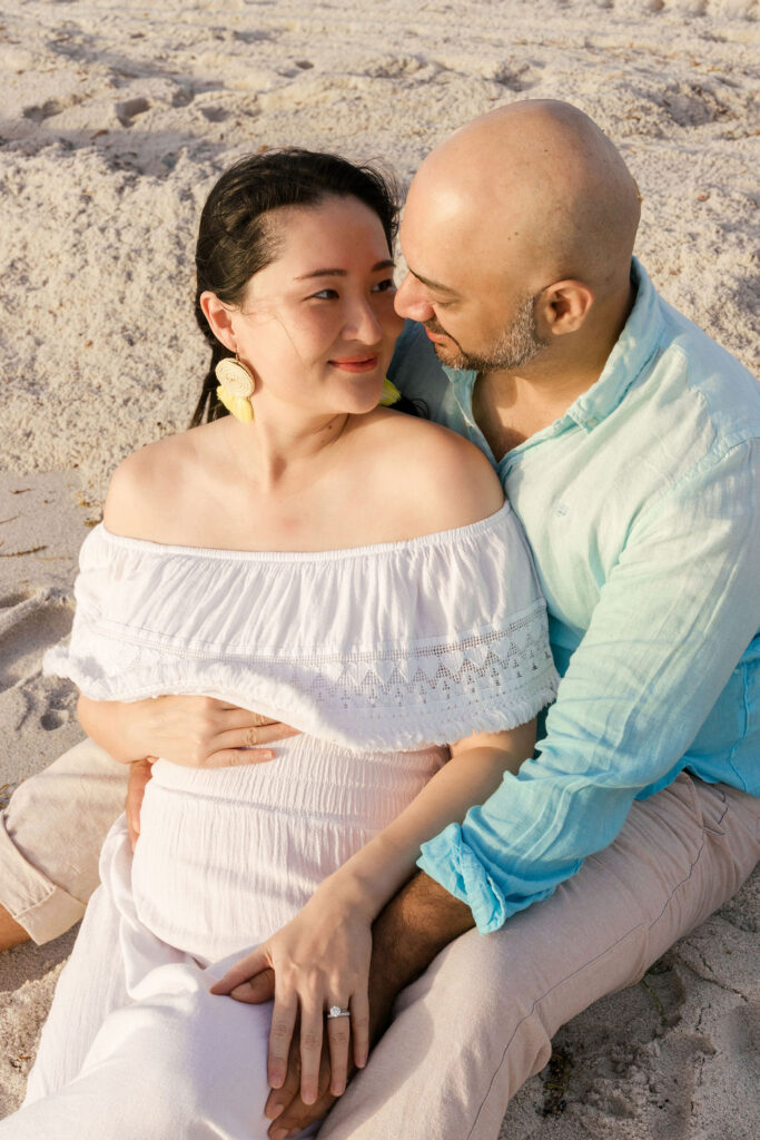 Romantic maternity beach session portrait of expecting couple in Miami.