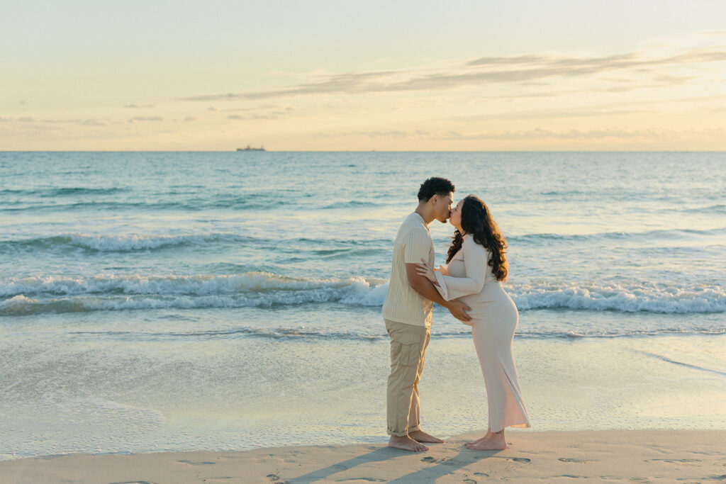 Romantic beach maternity photography session in South Florida during golden hour.